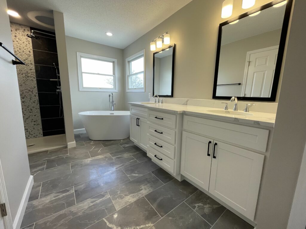 Remodeled bathroom with a double vanity and freestanding tub