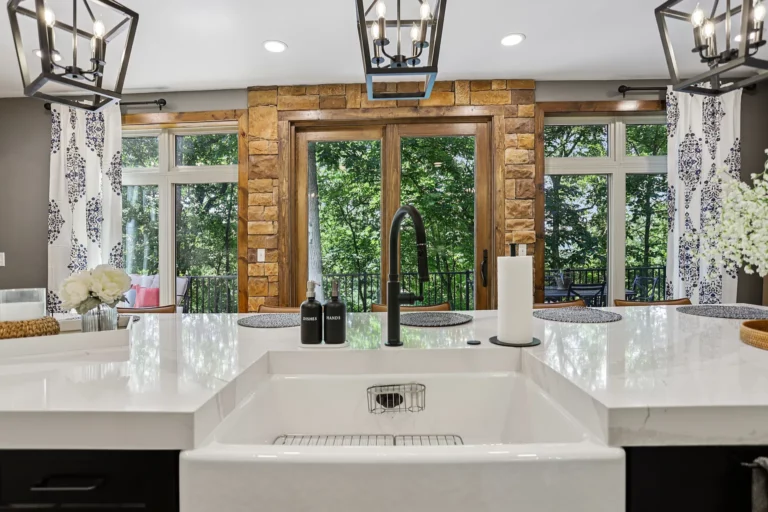 Farmhouse sink under a wide window with stone accents