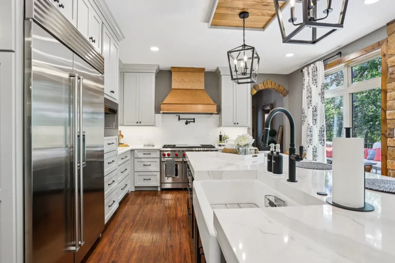 Kitchen with a custom range hood, stainless refrigerator, and hardwood floors
